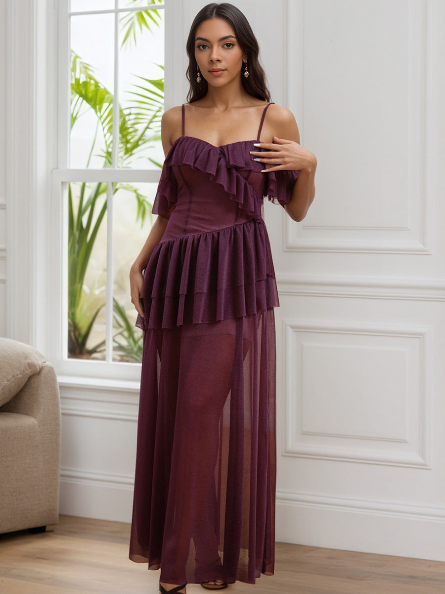 Woman wearing a grape dress with ruffled layers in a room with a window and plant.
